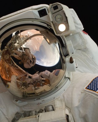 A close-up of Astronaut John Grunsfeld shows the reflection of Astronaut Andrew Feustel, perched on the robotic arm and taking the photo. The pair teamed together on three of the five spacewalks during Servicing Mission 4 in May 2009.